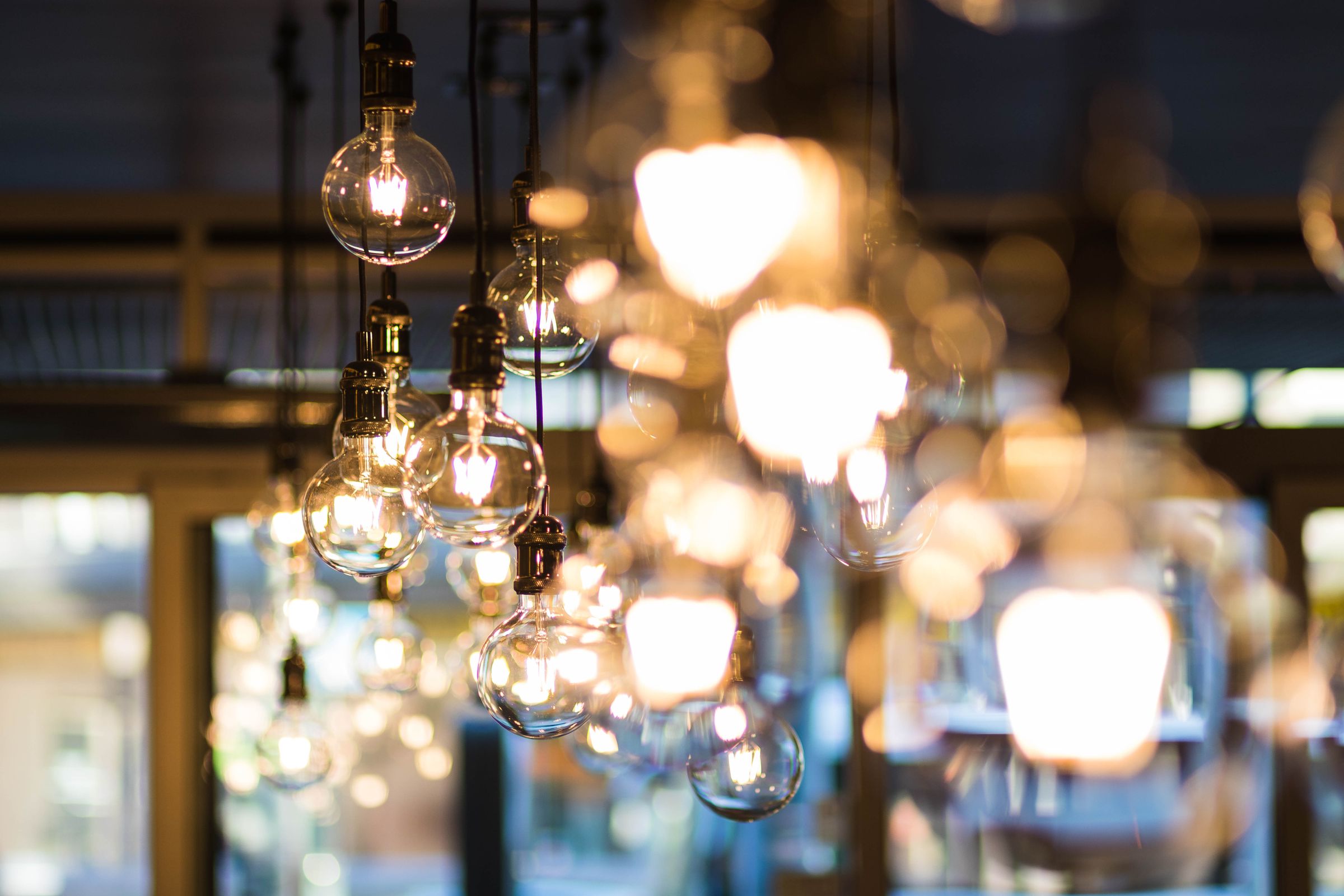 Warm filament bulbs glowing against a workshop window