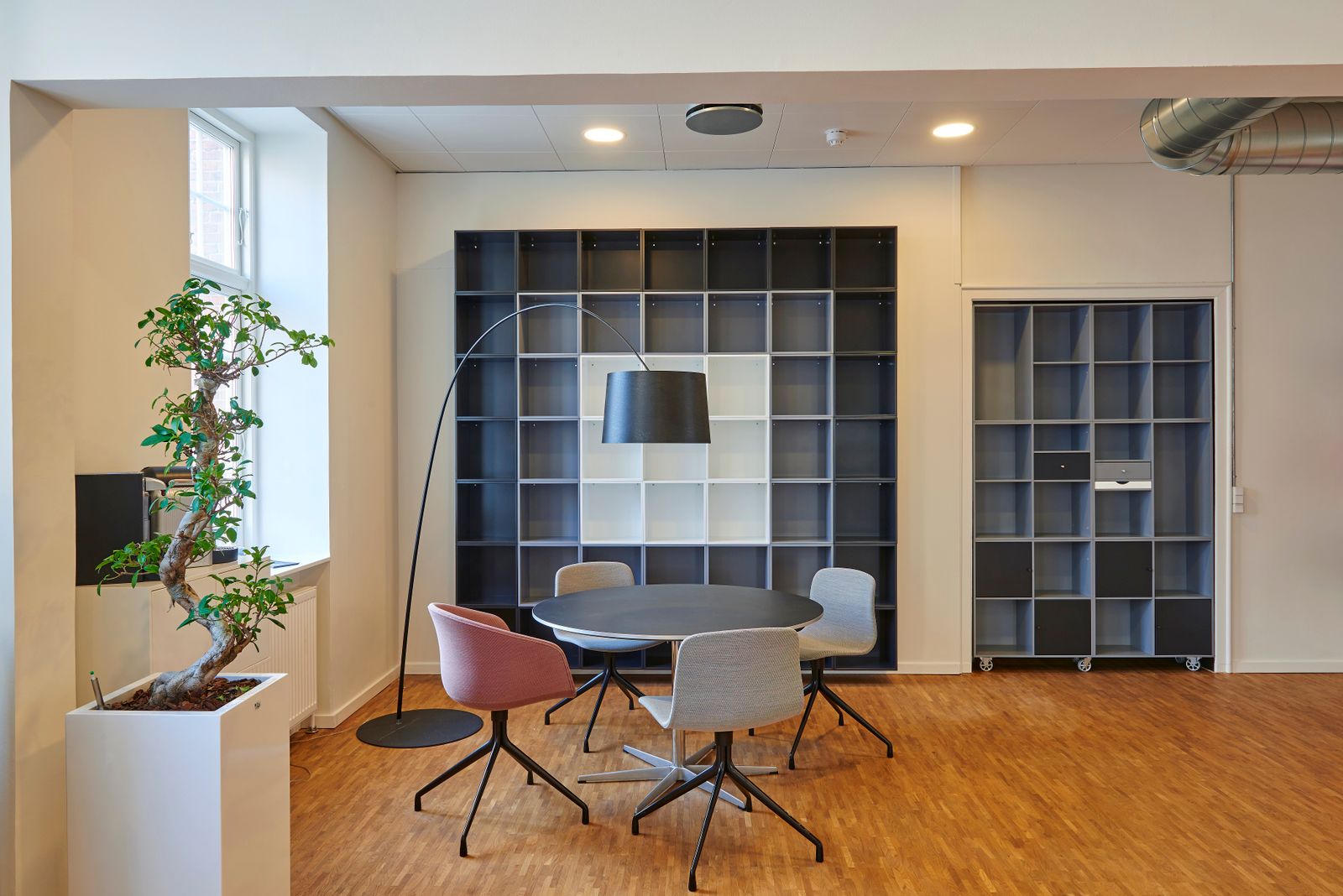 Meeting corner with grid shelving wall